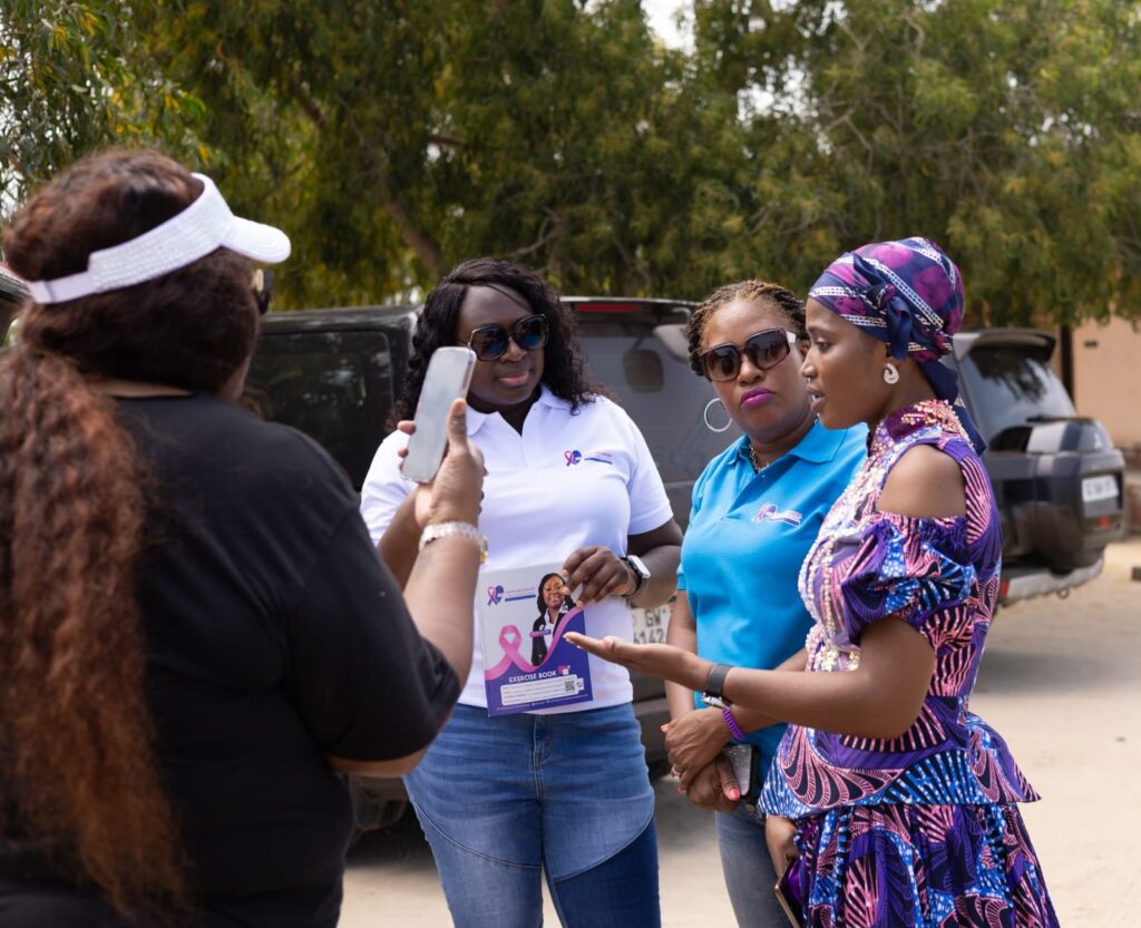 Queen mother of Ada in African print interacting with the team.